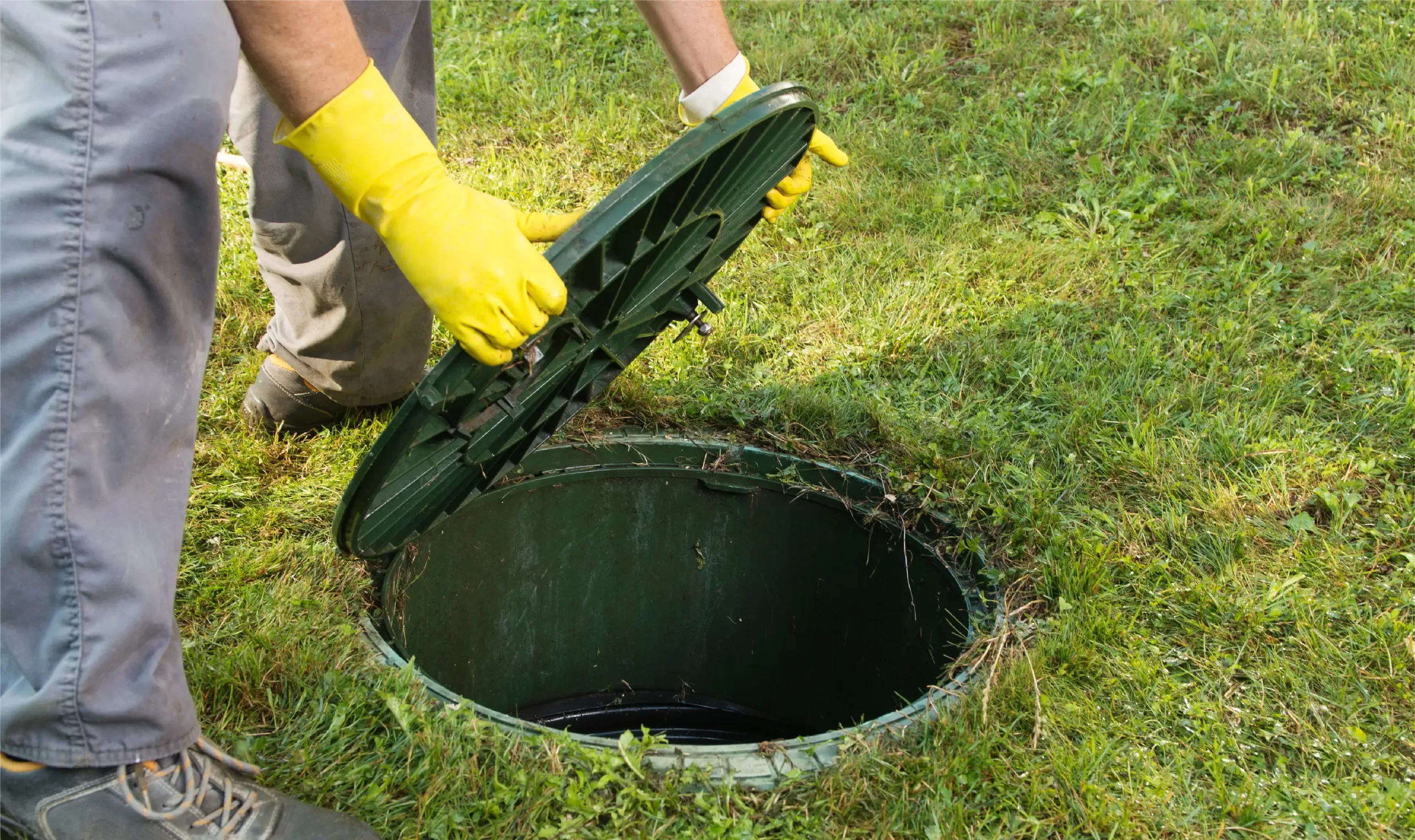 a homeowner opening the lid of septic tank to check for problems and maintain the system